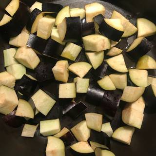 Pour 1 tablespoon of the olive oil in a skillet over medium heat. Add cubed eggplants, water and some salt too. Saute eggplants for 1 to 2 minutes then reduce the heat to medium low and cover skillet.