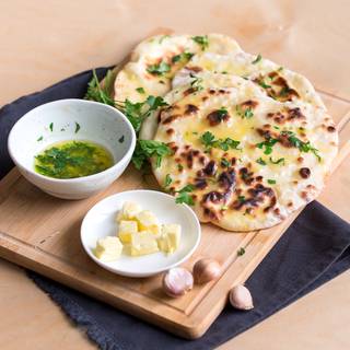 After greasing the naans with butter, spread parsley over them and enjoy while they are fresh and warm. 