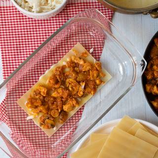 Add a layer of sheets and pour some cheese then pour chicken sauce. Repeat this step with lasagna, Béchamel sauce, chicken, and cheese until the dish is filled up.