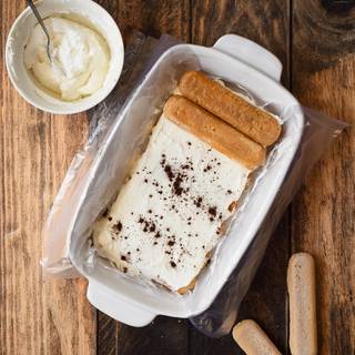 Add a cream cheese layer on top of the biscuits and then sprinkle some chocolate powder on the cream cheese. Add another layer of biscuits to the top of them. You can add 3 to 4 more layers.