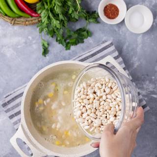 Add the corn, cooked white beans, and vegetable juice and cook for 15 minutes on medium heat.