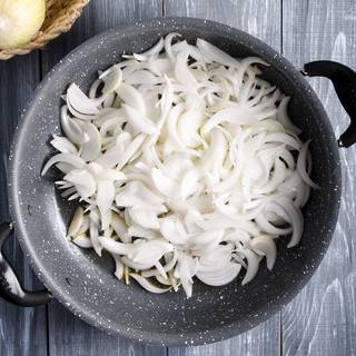 Wash and skin the onions and cut them into strips. Put the butter and olive oil in a pan on heat and wait until the butter is melted. Add the onions.