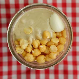 Add Peeled chickpeas, garlic, tahini, and sour lemon juice in the food processor to crush the chickpeas and garlic completely. 