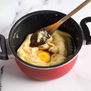 When the dough has finally cooled down, add the eggs to the dough one at a time and beat and mix them well. Now add the vanilla too.