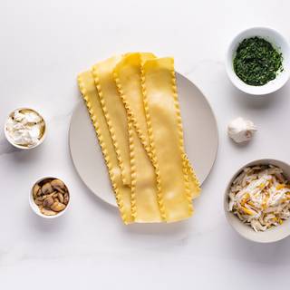 Cook the spinach with one clove of garlic and some oil. Cook the mushroom with oil, salt, and pepper. Boil the lasagna too. 