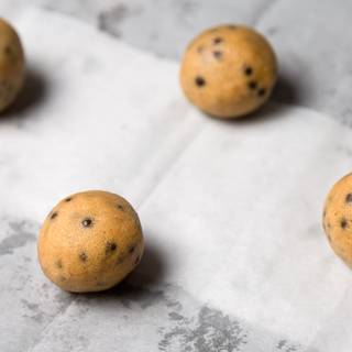Take the dough out of the refrigerator and allow it to slightly soften at room temperature. Roll the dough into balls, using an ice cream scoop helps you to have the same balls. Place the balls of dough onto each cookie sheet