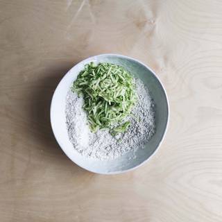 Grate zucchini and add to the flour, then combine them well.