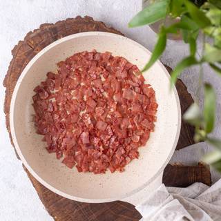 Fry the bacon slices in a pan, then keep them aside.