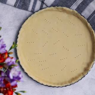 After one hour, roll out the dough with a rolling pin, then transfer it to a pie pan. Create small holes in the bottom with a fork to prevent your crust to rise.