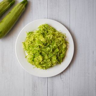 Wash the zucchinis and grate them. Add the zucchinis and walnuts to your dough and mix them completely.