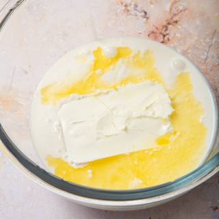 Meanwhile, pour mascarpone cheese, cream, powdered sugar, vanilla, and orange juice in a large bowl.