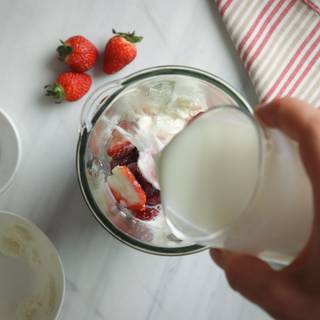 Add milk to the ice cream and strawberries.