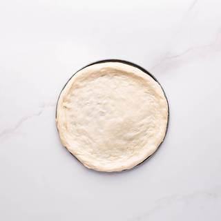 Open the pizza dough from the middle and by hand until it reaches the edge of the dish. Hold the edge of the dough slightly and do not flatten it.