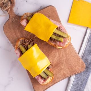 Put pickles and the gouda cheese on top of each other and finally place the other side of the baguette on top of your sandwich.