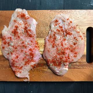 pound both sides of the chicken breast with a mallet to a thickness of almost 1/2 inch. then season both sides of each chicken breast with paprika, oregano, black pepper and salt. 