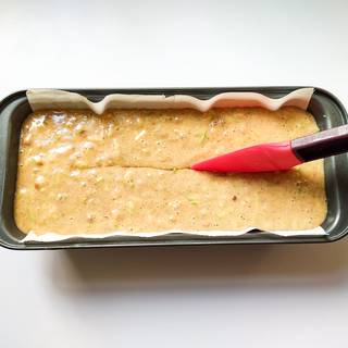 Put parchment paper at the bottom of the loaf pan and pour the batter into the loaf pan. Dip an oil-covered spatula and make a slit in the middle of the cake if you want to have a crack in the middle.