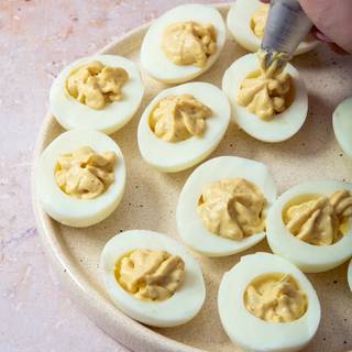 Using a small spoon or cookie scoop, fill the egg white halves with the yolk mixture.