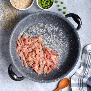 Melt the butter on the pan and fry the chopped onions inside it. Add the cubed chicken breast and fry it as well.