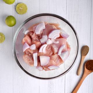Chop a big onion into large pieces and mix it with the chicken.