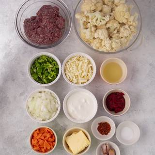 Prepare the shepherd's pie ingredients. Cut the cauliflower into small pieces. Chop the rest of the vegetables.