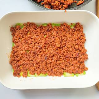 Layer half of the minced meat on the zucchini Layer, and pour 1/2 a spoon of chopped basil on the meat.