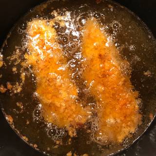 Heat the frying oil in a small pot. Place the chicken fillets in the pot.